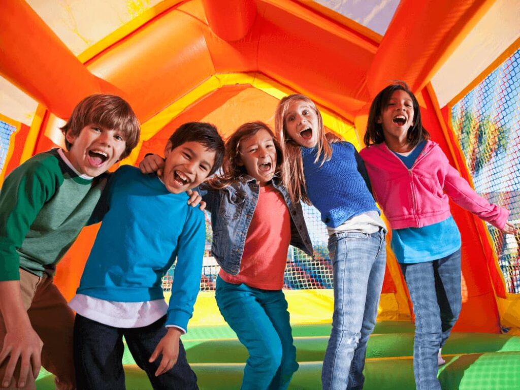 Children jumping in a colorful bounce house at a party